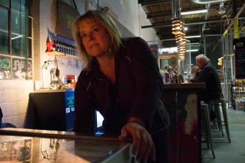 Englewood, Colo. – April 22, 2017 – Lowry resident, Joan Heller keeps both eyes on the scoreboard as she drops a quarter in her favorite pinball machine at Devil’s Head Distillery. Heller is competitive by nature and plays to win whenever the silver ball drops onto the playfield. (Derek Gregory)